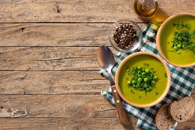 Green pea soup in a bowl on rustic wooden table Top view Copy space