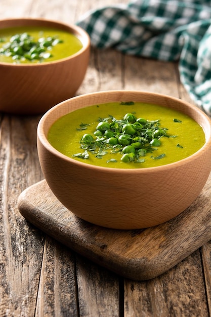 Green pea soup in a bowl on wooden table