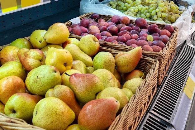 Green pears in box in grocery department of supermarket, store, shop, shopping center. Sweet summer