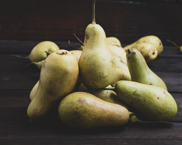 Photo green pears on a brown wooden background