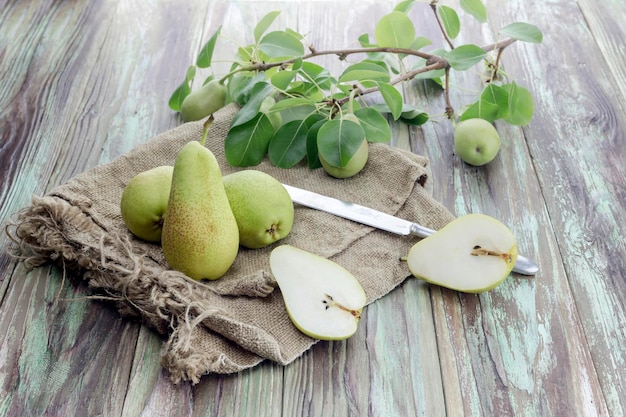 Green pears and knife on a wooden