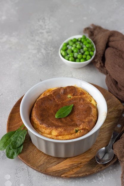 Green peas and cheese souffle on a wooden plate