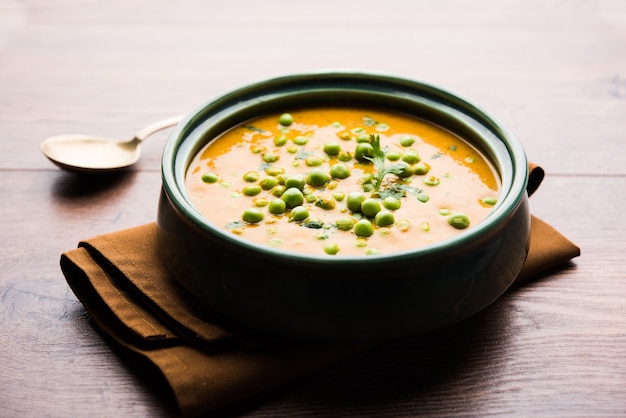 Green Peas curry or Matar masala served in a bowl over moody background. selective focus