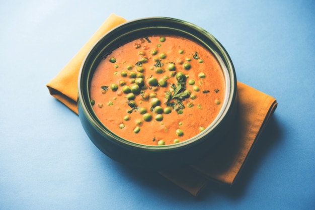 Green Peas curry or Matar masala served in a bowl over moody background. selective focus