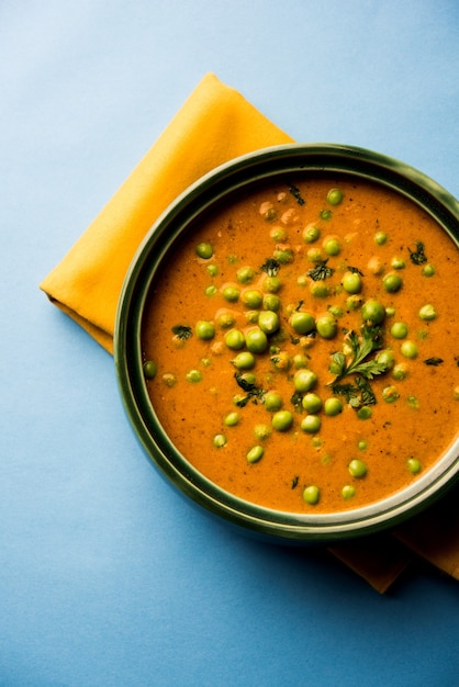 Green Peas curry or Matar masala served in a bowl over moody background. selective focus