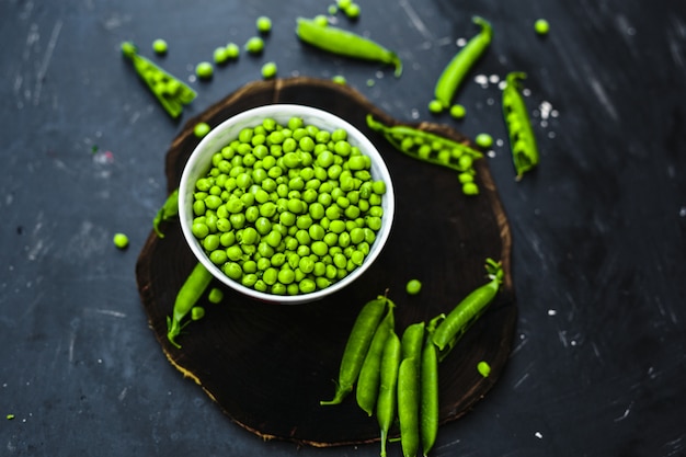 Green Peas and fresh grain on an old wooden table.