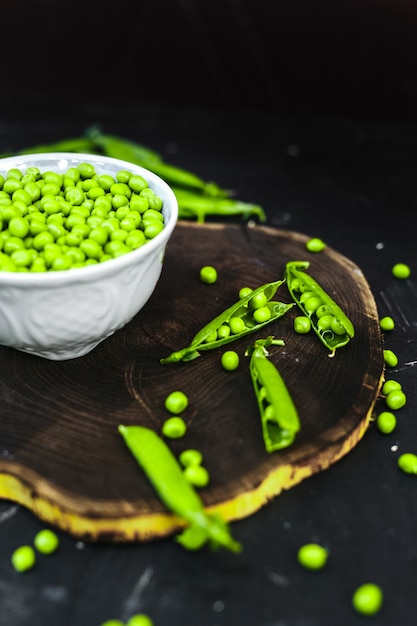 Green Peas and fresh grain on an old wooden table.