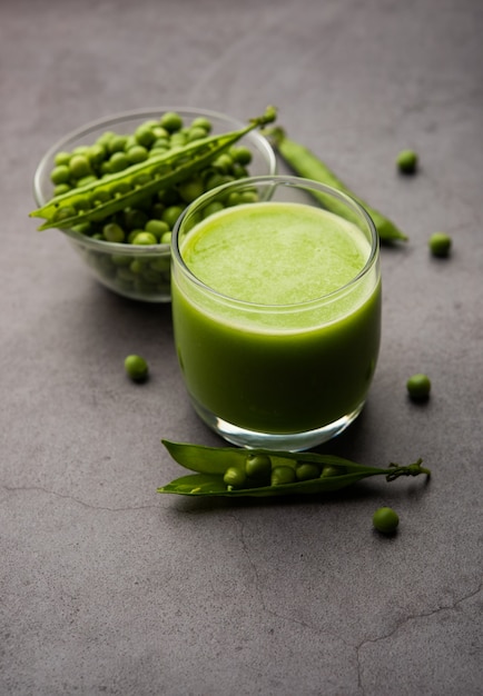 グリーンピースフレッシュジュースまたはスムージーまたはワタナまたはバタナを使用して作られた飲み物、グラスで提供されるインドの健康的なグリーン飲料