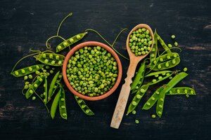 green peas in a wooden plate on a wooden background top view free space for your text