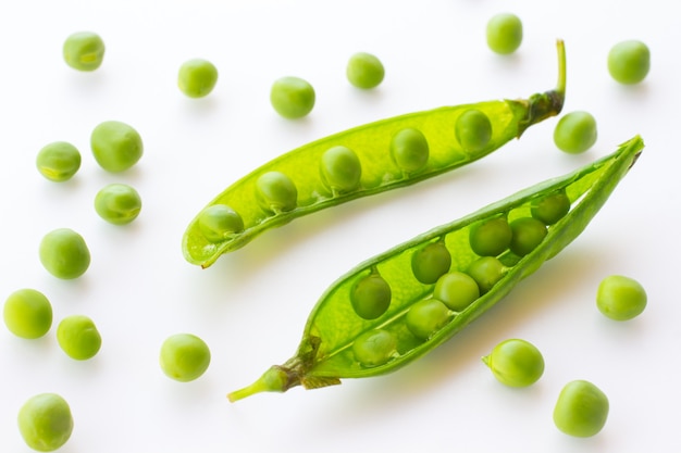 Green peas and pea pod close up on white. Top view.