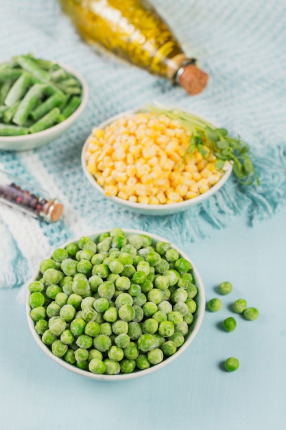 녹색 완두콩, 달콤한 옥수수 및 그릇에 녹색 콩을 잘라. 빠른 요리를위한 수제 준비의 개념입니다. 건강한 채식 음식 개념