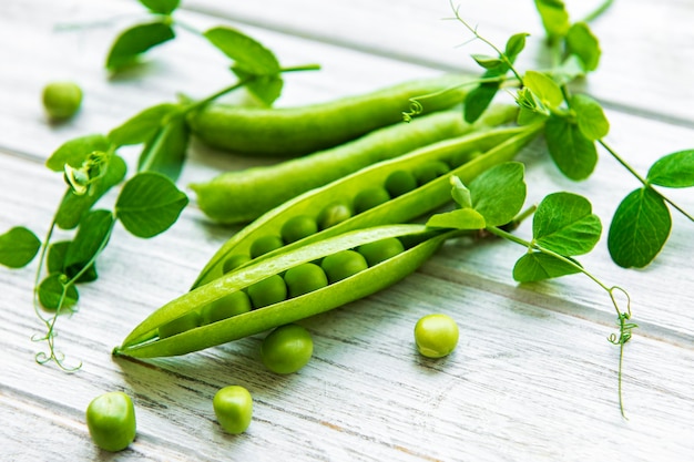 Green peas  on a white wooden background.  Healthy food background.