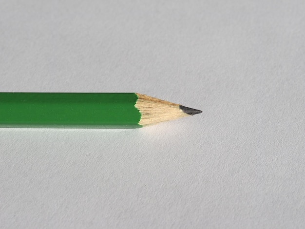 Зеленый карандаш на листе бумаги