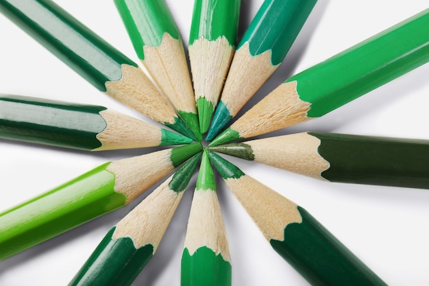 Green pencils of different shades on white background