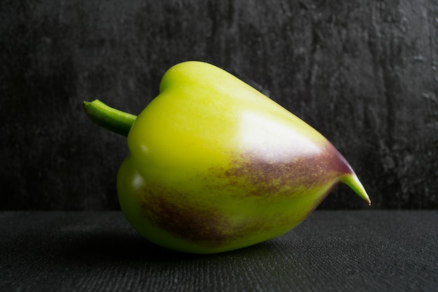 Green pepper on black background.