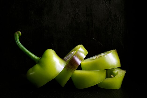 Green pepper on black background.