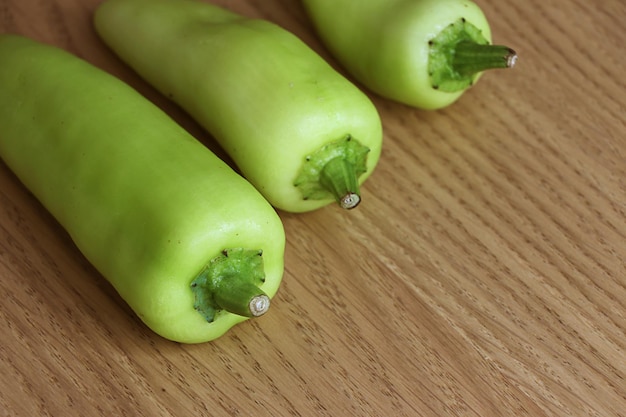 Green pepper on wooden background.