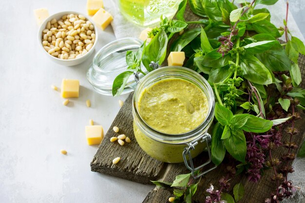 Green pesto sauce basil parmesan and pine nuts on a stone or slate table Copy space