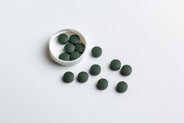 Фото Зеленые таблетки, изолированные на белом фоне