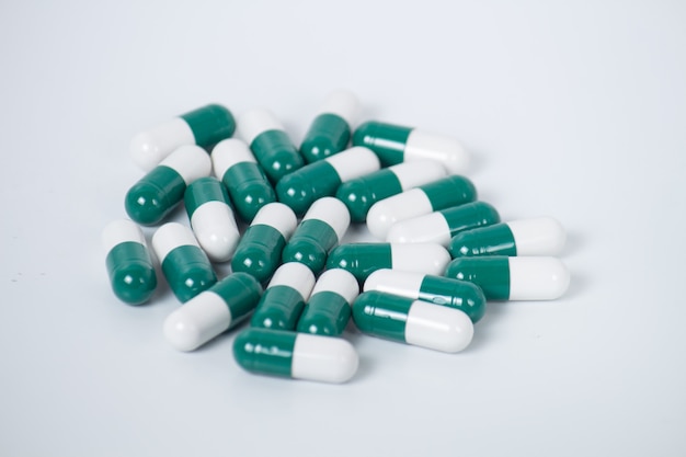 Foto pillole verdi una bottiglia di pillola su fondo bianco
