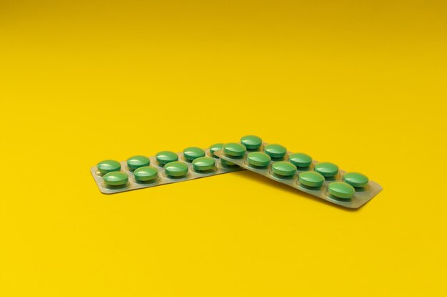 Green pills on a yellow background