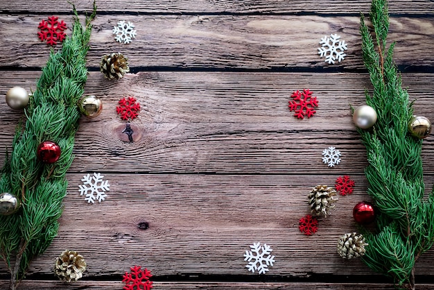 Green pine, golden pine cone, snowflakes, Christmas ornaments ball on wooden background with copy space