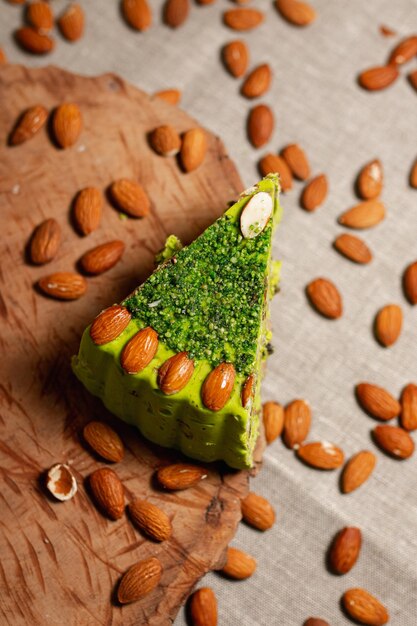 green pistachio cake garnished with almond nuts