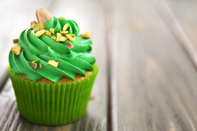 Green pistachio cupcake on wooden background