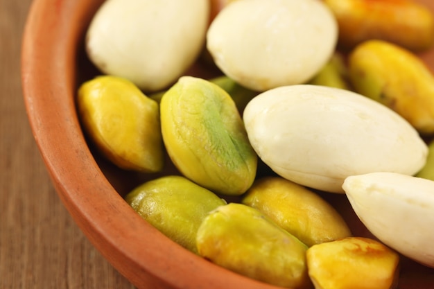 Green Pistachios with peeled almond on a bowl