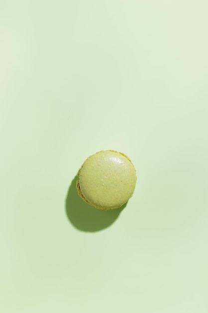 Green pistacio colored macaroon on green background Gift for 8 March International Women's Day Valentine Day