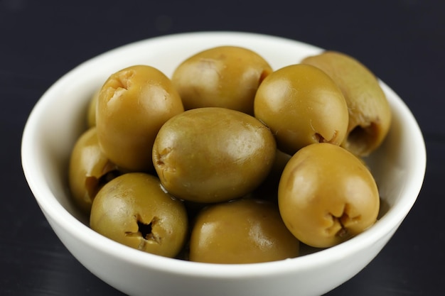 Green pitted olives in a white plate White plate with delicious pitted green olives