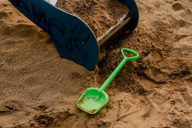 Green plastic children's shovel on the playground
