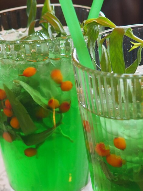 A green plastic container with red berries in it.