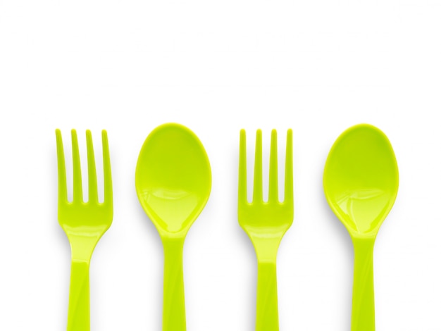 Green plastic spoon and fork isolated on white 