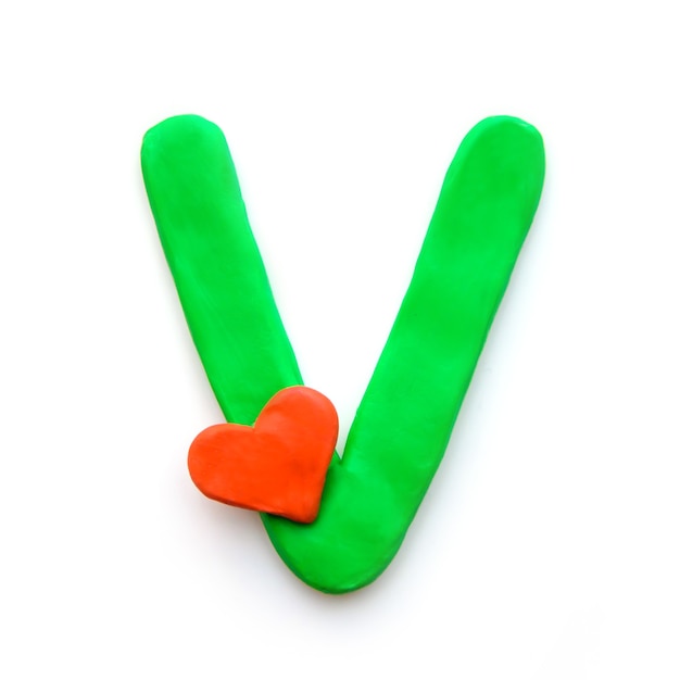 Green plasticine letter V English alphabet with red heart meaning love