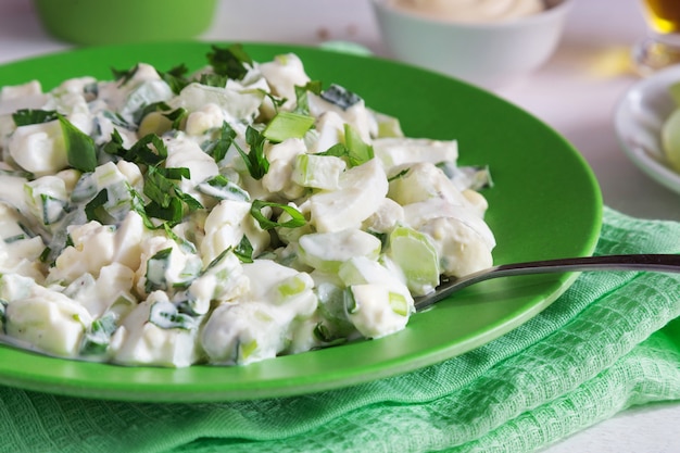 Green plate of celery salad with dressing and parsley