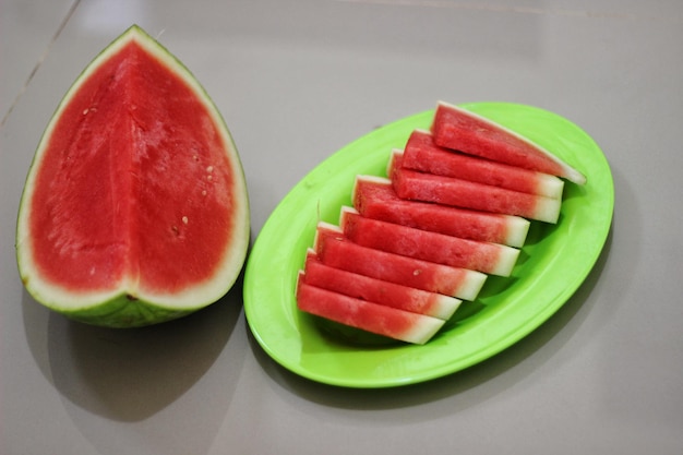 Photo a green plate with watermelon on it and a green plate with watermelon on it