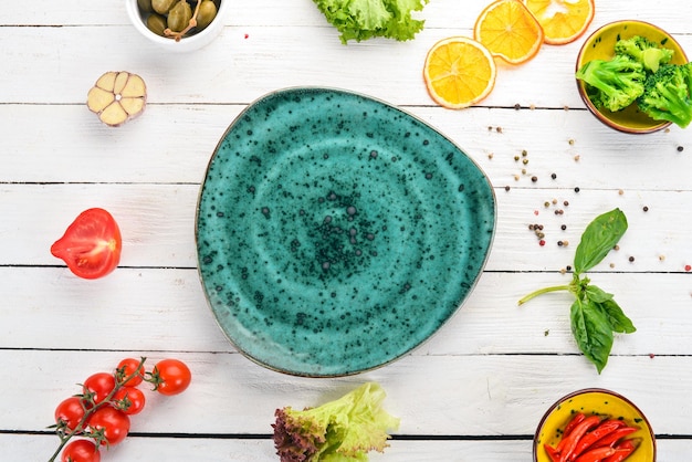 Green plate on a wooden background with vegetables On a wooden table Top view Copy space