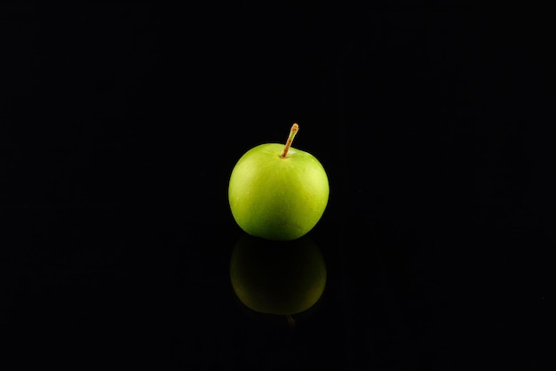 Green plums on black background