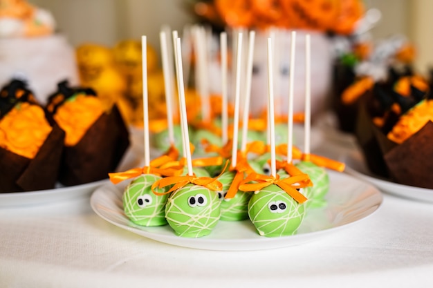 Green pop cakes on the candy bar for the celebration of Halloween