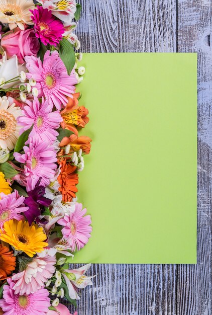 Foto cartolina verde con mazzo di fiori colorati