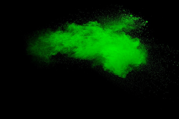 Взрыв зеленого порошка на черном фоне.