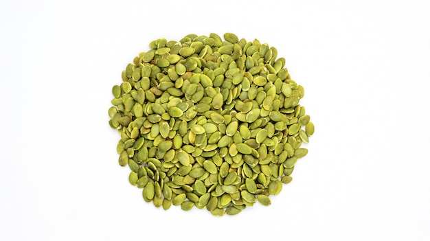 Green pumpkin seeds on a white background