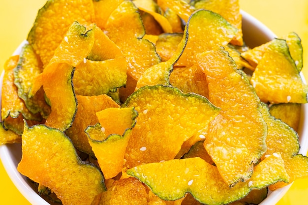 Chip di fetta di zucca verde su sfondo giallo