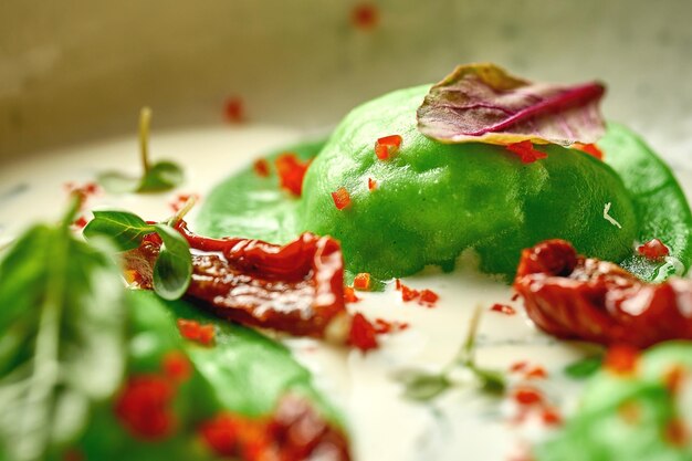 Green ravioli with minced chicken in cream sauce Selective focus Closeup