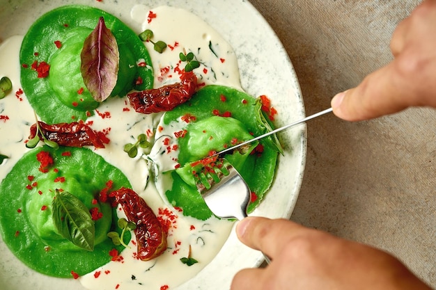 Green ravioli with minced chicken in cream sauce Selective focus Closeup