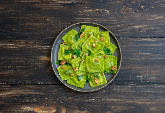 Green ravioli with ricotta cheese, spinach and nuts. Healthy eating. Vegetarian food. Italian cuisine.