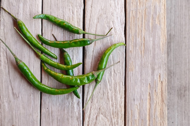 Green raw chili on wooden surface