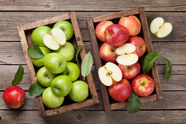 Photo green and red apples in wooden box