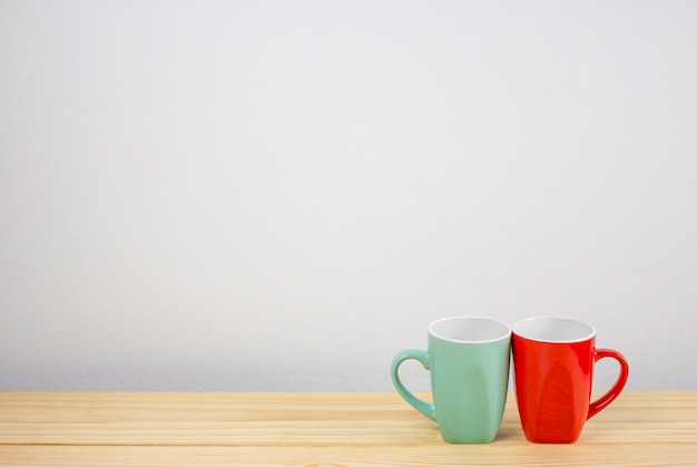 green and red coffee mug on wooden table